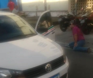 Ensanguentado, motorista é socorrido por populares em calçada da Rua Dias Cabral, no Centro